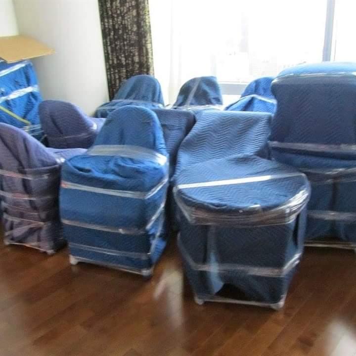 Chairs wrapped with blue moving blankets — professional packing service UAE
