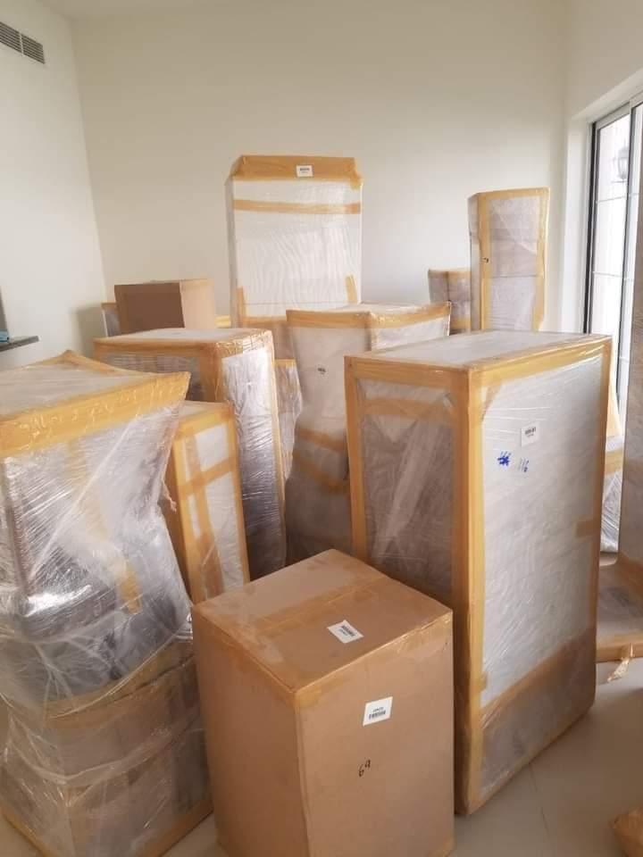 Wrapped furniture items in room ready to move — safe packing UAE